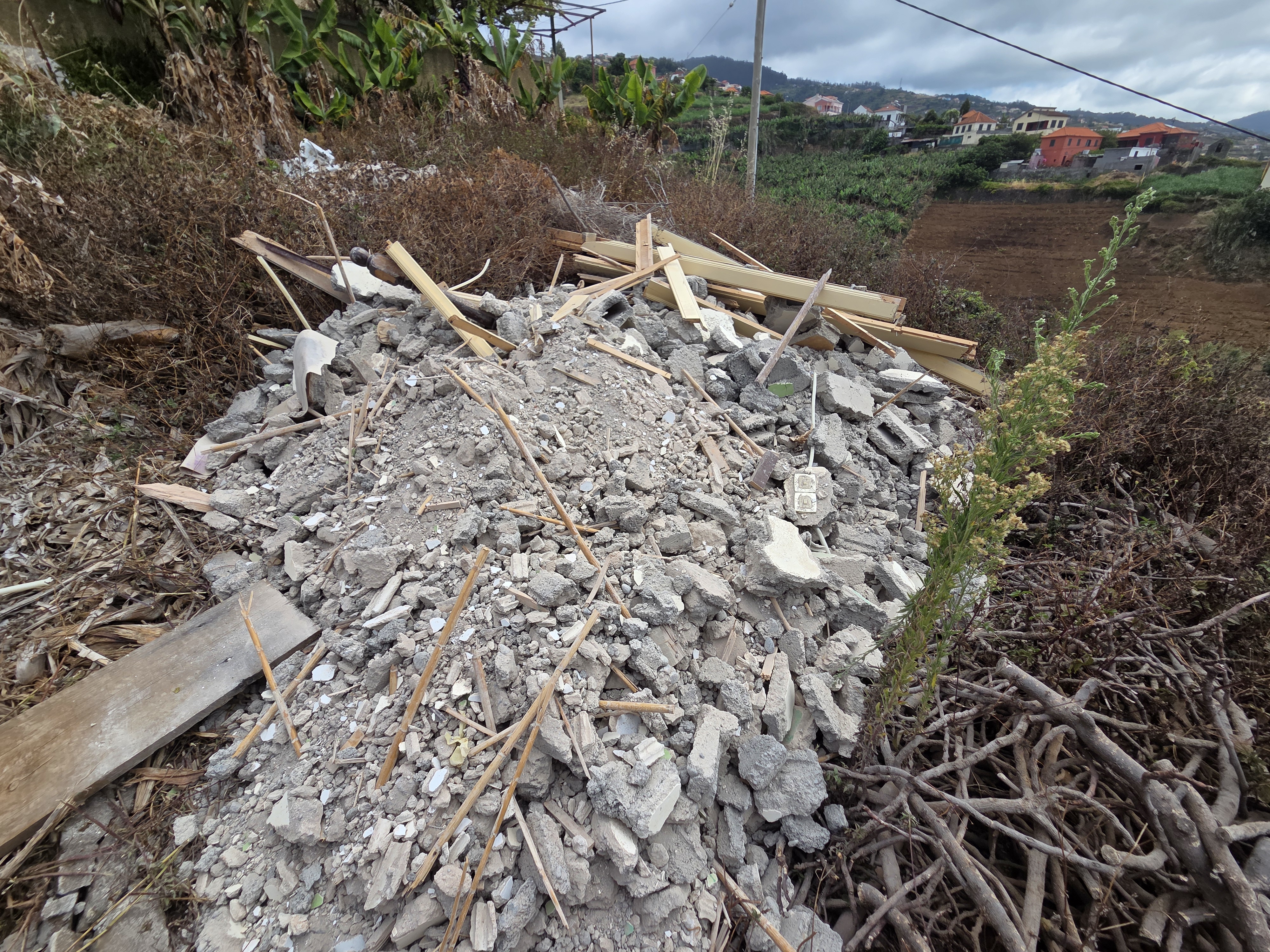Bauschutt und Holzreste auf einem Gelände mit Blick auf die Umgebung